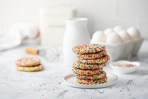 Sugar cookies with sprinkles and a bottle of milk photo