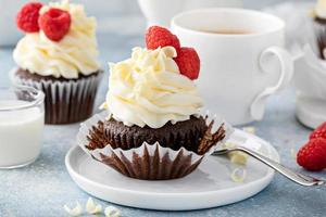 Chocolate cupcakes with white chocolate frosting and raspberries