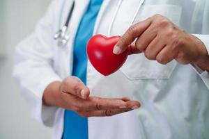 Asian woman doctor holding red heart for health in hospital. photo