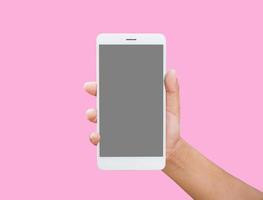 Human hand holding blank screen smart phone isolated on pink background. photo