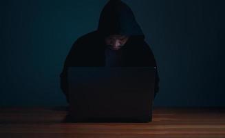 Hackers work on laptops in the dark. The concept of information security in the Internet network and information espionage. photo