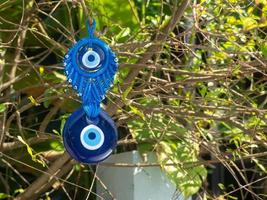 Close up of evil eye charms hang from a tree. photo