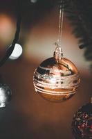 Gold Christmas Ornament Hanging on a Christmas Tree photo