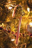 bastón de caramelo colgando de un árbol de Navidad con luces suaves foto