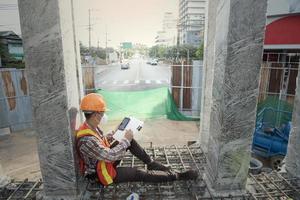 trabajador engenre proceso de construcción y toma de notas. foto de un contratista que completa el papeleo en un sitio de construcción.