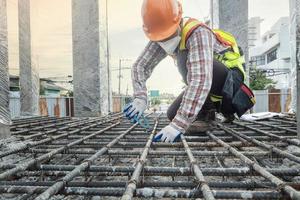 trabajadores de la construcción que fabrican barras de refuerzo de acero en el sitio de construcción foto