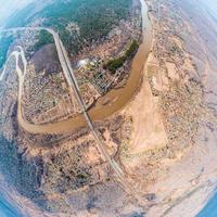 Disparo de drones de helicóptero. fotografía aérea de un área, gran pueblo con casas pequeñas, un bosque verde y un gran campo en un cálido día soleado de verano. ciudad panorámica 360 tomada desde arriba foto