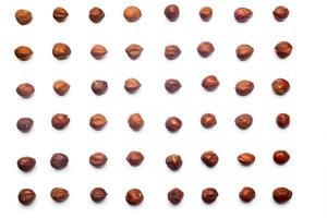 A collection of  hazelnuts lie in horizontal rows on an isolated white background. with clipping path.  hazelnuts pattern photo