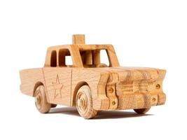 Photo of a wooden  police car  of beech. Toy made of wood retro car on a white isolated background