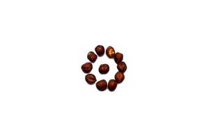 A collection of hazelnut nuts lie in the shape of a circle or sun on an isolated white background with a clipping path. Hazelnut pattern photo