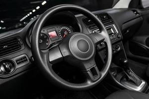 dashboard, speedometer, tachometer and steering wheel with wooden inserts with phone setting and volume buttons. Luxurious car interior details