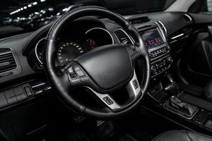 dashboard, speedometer, tachometer and steering wheel with wooden inserts with phone setting and volume buttons. Luxurious car interior details