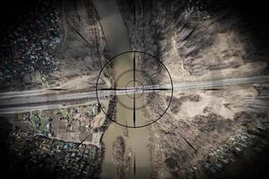 Close up, a small town, a village with small houses, a river, a bridge, roads and other strategically important objects to be under the gun and shadowed. Concept of computer game and spying on people photo