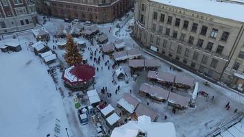 hermoso país de las maravillas de invierno sobre el casco antiguo de riga. mercado navideño con árbol de navidad en el centro de la ciudad. espíritu mágico de vacaciones en europa. vista aérea. video