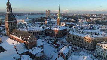 Beautiful winter wonderland over Riga old town. Christmas market with Christmas tree in the center of the city. Magical holiday spirit in Europe. Aerial view. video