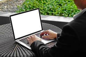 enfoque selectivo del botón táctil de la mano del hombre de negocios en el teclado del portátil. hombre usando computadora portátil con pantalla en blanco. hombre que trabaja en la computadora portátil con las dos manos. fondo del concepto de negocio. foto