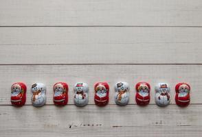 Traditional Christmas ornaments, Santa Claus, Snowman, isolated on wooden background. Top view. Flat lay photo