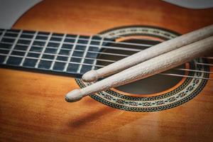Detail of drumsticks on acoustic guitar photo
