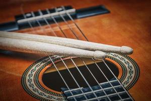 Acoustic guitar with drum sticks photo