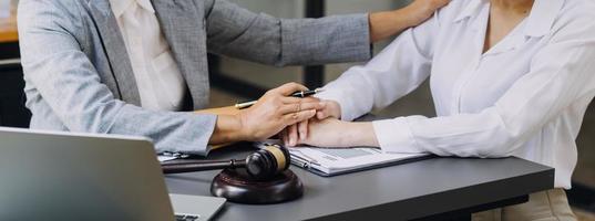 Justice and law concept.Male judge in a courtroom with the gavel, working with, computer and docking keyboard, eyeglasses, on table in morning light photo