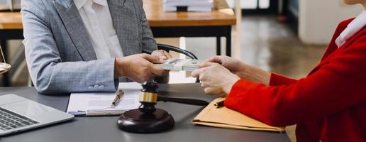 Justice and law concept.Male judge in a courtroom with the gavel, working with, computer and docking keyboard, eyeglasses, on table in morning light photo