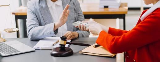 Justice and law concept.Male judge in a courtroom with the gavel, working with, computer and docking keyboard, eyeglasses, on table in morning light photo