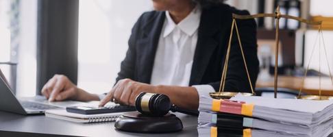 law books and scales of justice on desk in library of law firm. jurisprudence legal education concept. photo