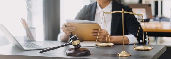 law books and scales of justice on desk in library of law firm. jurisprudence legal education concept. photo