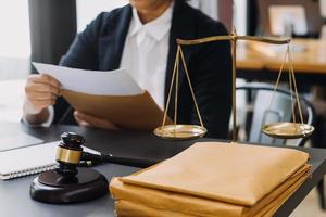 justice and law concept.Male judge in a courtroom on wooden table and Counselor or Male lawyer working in office. Legal law, advice and justice concept. photo