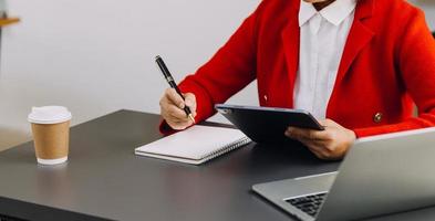 Businessman hands working with finances about cost and calculator and laptop with tablet, smartphone at office in morning light photo