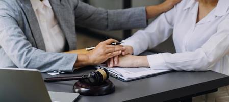 Business and lawyers discussing contract papers with brass scale on desk in office. Law, legal services, advice, justice and law concept picture with film grain effect photo