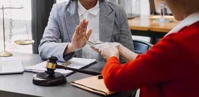 concepto de justicia y derecho. juez masculino en una sala de audiencias sobre una mesa de madera y consejero o abogado masculino que trabaja en el cargo. derecho legal, asesoramiento y concepto de justicia. foto