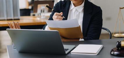 justice and law concept.Male judge in a courtroom on wooden table and Counselor or Male lawyer working in office. Legal law, advice and justice concept. photo