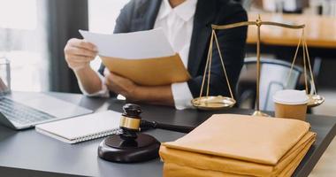 Justice and law concept.Male judge in a courtroom with the gavel, working with, computer and docking keyboard, eyeglasses, on table in morning light photo