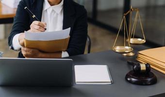 law books and scales of justice on desk in library of law firm. jurisprudence legal education concept. photo