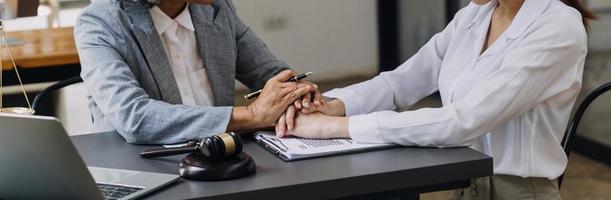 Business and lawyers discussing contract papers with brass scale on desk in office. Law, legal services, advice, justice and law concept picture with film grain effect photo