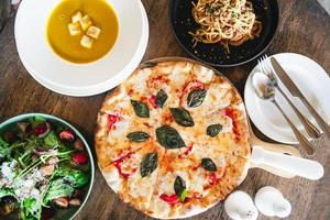 vista superior de las comidas italianas en la mesa pizza, pasta, sopa, ensalada de verduras. foto