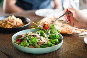 comiendo ensalada. gente comiendo comida italiana pasta, pizza, ensalada en la mesa. foto