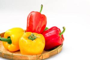 Red and yellow bell peppers in bamboo baskets on white background. soft and selective focus. photo