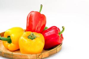 Red and yellow bell peppers in bamboo baskets on white background. soft and selective focus. photo