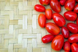 Fresh red ripe tomatoes on a bamboo weaving background. soft and selective focus. photo