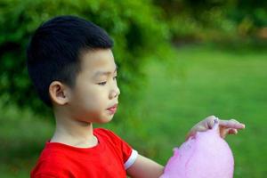 holding  pink cotton candy on sky background. Cotton candy made from sugar spun into thin noodles. Like a cloud, many colors depending on the color. Soft and selective focus. photo