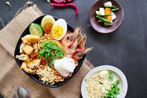 laksa, laksa curry made from vermicelli, noodles, bean sprouts, egg, tofu lime, and shrimp with a spicy soup sauce that is rich in spices. laksa served on bowl, isolated on white background. photo