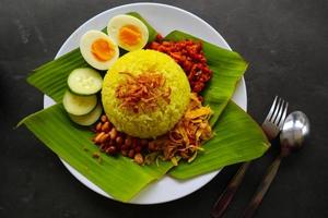 nasi kuning or yellow rice or tumeric rice is traditional food from asia, made rice cooked with turmeric, coconut milk r photo