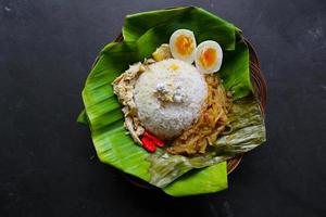 nasi liwet solo o sego liwet solo es una comida tradicional de surakarta. hecho con arroz salado, chayote y huevo cocido, pollo, leche espesa de coco servido en una hoja de plátano foto