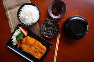 chicken katsu don is japanese food served with soy sauce on table photo