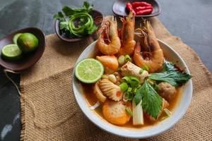 Tom yam soup originating from Thailand. Tom yum is made with shrimp, chili, lime, chicken, fish, or seafood and mushrooms. photo