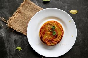 paratha bread or canai bread or roti maryam, favorite breakfast dish. served on plate photo