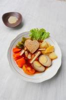 selat solo is traditional salad food from indonesia. made from hard-boiled eggs, boiled chickpeas, boiled carrots, hash browns and lettuce, steak or bistik. served on wood table photo