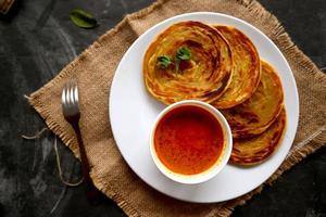 paratha bread or canai bread or roti maryam, favorite breakfast dish. served on plate photo